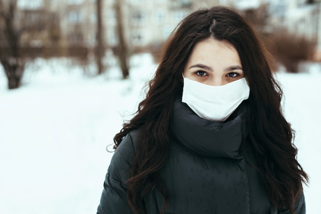 Retrato de uma mulher branca em uma máscara médica durante uma epidemia