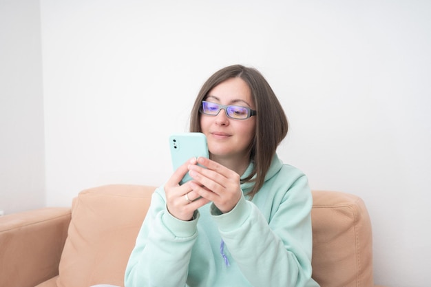 Retrato de uma mulher casual sorridente segurando smartphone sobre fundo branco