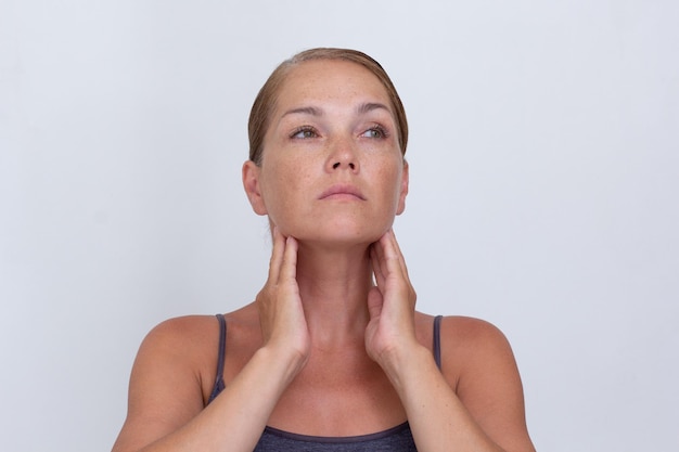 Foto retrato de uma mulher caucasiana de meia-idade examinando os gânglios linfáticos no pescoço para diagnosticar o linfoma hy