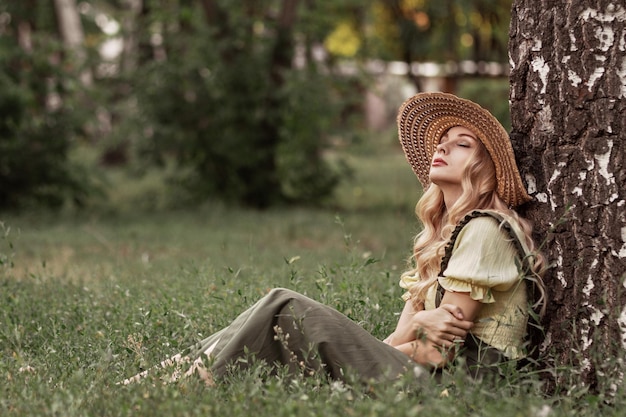 Retrato de uma mulher com cabelo loiro em roupas retrô em um parque ou jardim