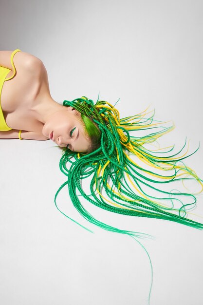 Foto retrato de uma mulher com cabelos coloridos de forma criativa nas cores verde e amarelo