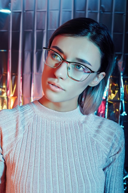 Retrato de uma mulher com óculos de reflexão de néon ao fundo