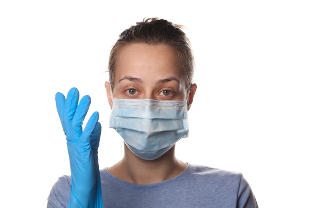 Retrato de uma mulher com uma máscara médica e luvas isoladas em branco. proteção contra pandemia covid-19