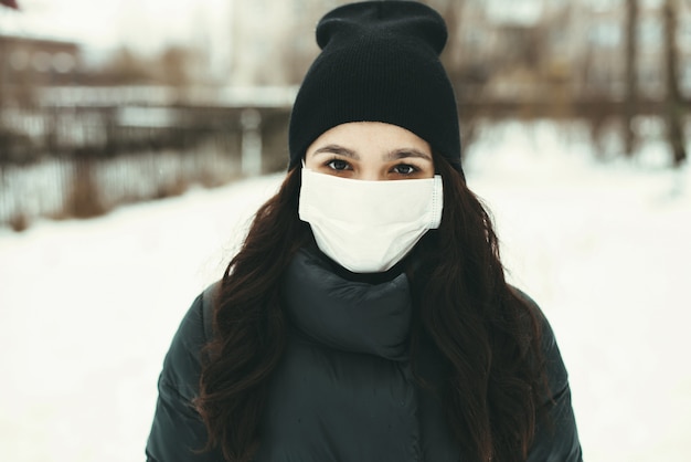 Retrato de uma mulher com uma máscara médica para proteger contra o vírus durante uma epidemia