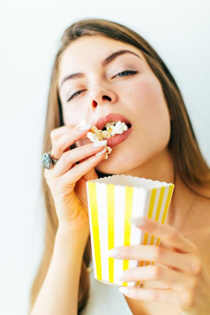 Foto retrato de uma mulher comendo pipoca