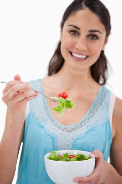 Retrato de uma mulher comendo uma salada