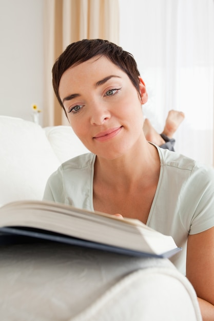 Foto retrato de uma mulher de cabelos curtos lendo um livro