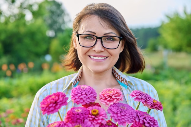 Retrato de uma mulher de meia idade com um buquê de flores ao ar livre