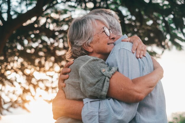 Foto retrato de uma mulher de meia idade de cabelos grisalhos felizes aconchegando-se ao sorridente marido mais velho