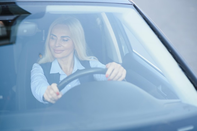 Retrato de uma mulher de meia idade elegante de negócios no carro