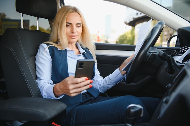 Retrato de uma mulher de meia idade elegante de negócios no carro