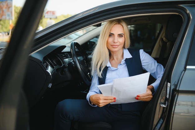 Retrato de uma mulher de meia idade elegante de negócios no carro