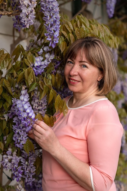 Retrato de uma mulher de meia-idade em flores Fundo floral Felicidade e alegria