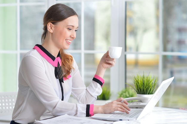 Retrato de uma mulher de negócios agradável com um laptop