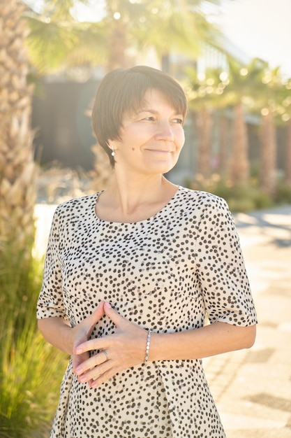 Retrato de uma mulher de negócios caucasiana feliz de 50 anos posando e sorrindo no parque, uma senhora real saudável e adulta no fundo da natureza