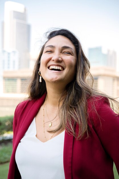 Foto retrato de uma mulher de negócios de pé ao ar livre no centro da cidade rindo