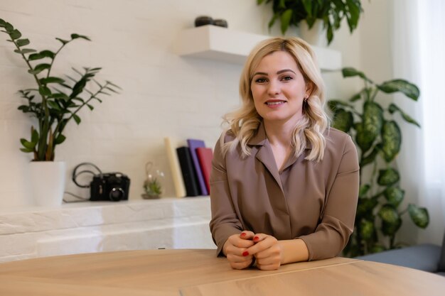 Retrato de uma mulher de negócios feliz e casual sentada em seu local de trabalho no escritório