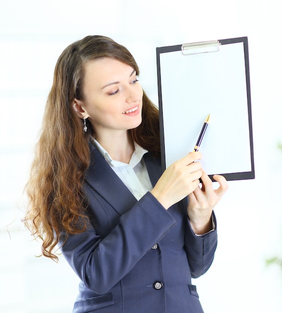 Retrato de uma mulher de negócios jovem bonito com o plano de trabalho sorrindo.