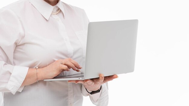 Retrato de uma mulher de negócios segurando um laptop de prata no escritório isolado