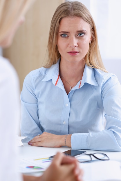 Retrato de uma mulher de negócios séria sentada à mesa