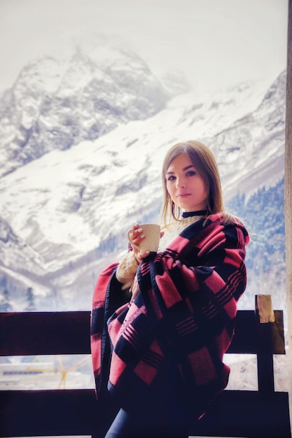 Foto retrato de uma mulher de pé em uma montanha coberta de neve