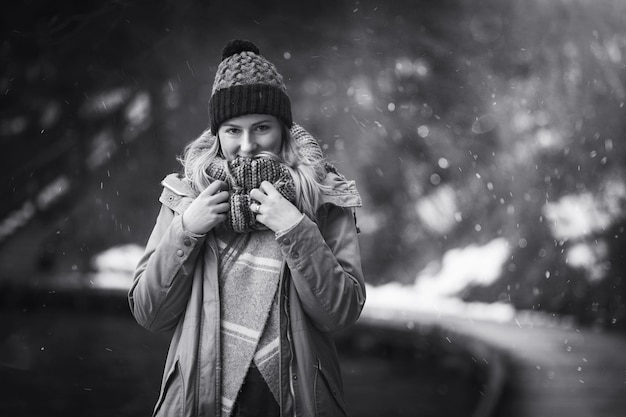 Retrato de uma mulher de pé no cais durante a queda de neve