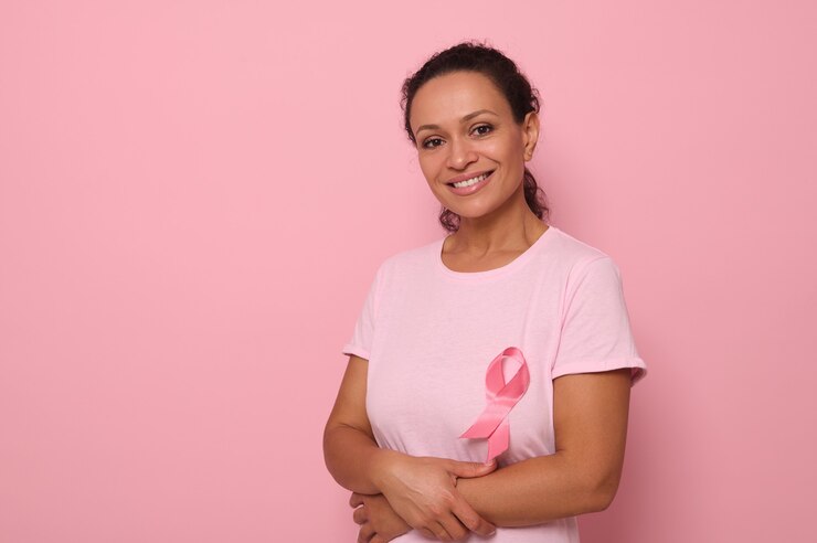 Foto retrato de uma mulher de raça mista altruísta e sorridente, com uma camiseta rosa com uma fita de cetim rosa, símbolo do dia internacional do câncer de mama. programa educativo de luta contra o câncer. 1 ° de outubro