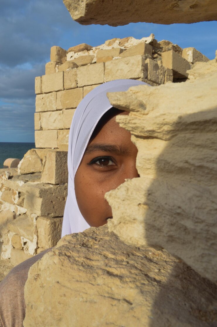 Foto retrato de uma mulher de um olho atrás de uma rocha