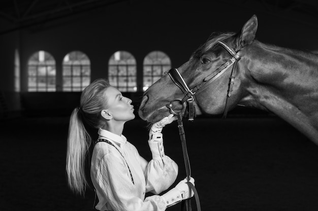 Retrato de uma mulher elegante abraçando um cavalo puro-sangue. conceito de amor e carinho. mídia mista