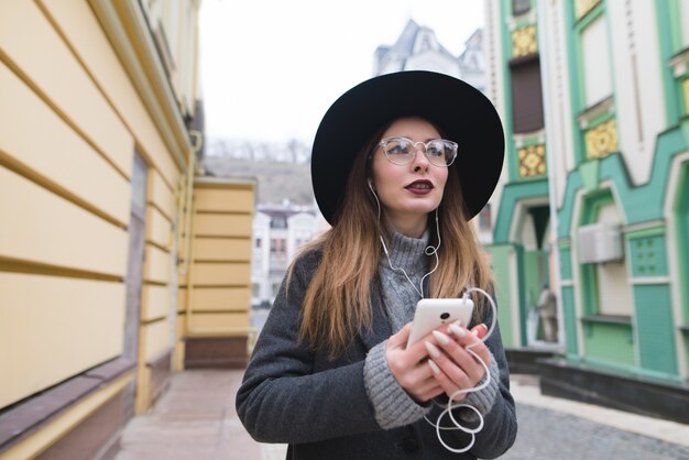 Retrato de uma mulher elegante, ouvindo música em fones de ouvido