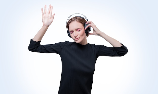 Retrato de uma mulher em fones de ouvido profissionais. fundo branco. conceito de dj. mídia mista