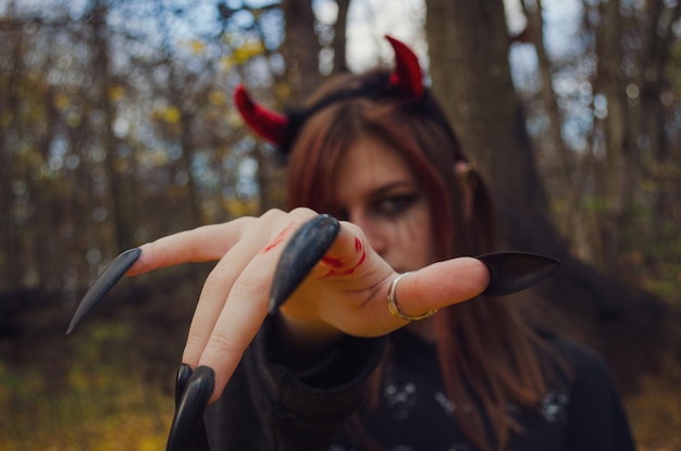 Foto retrato de uma mulher em um vestido de halloween em chifres vermelhos