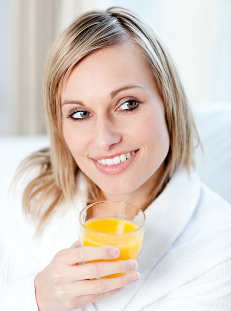 Retrato de uma mulher encantadora segurando um suco de laranja