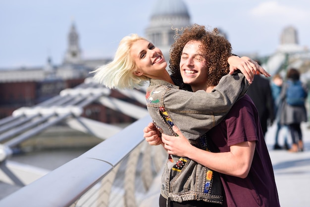 Retrato de uma mulher feliz abraçando um homem na ponte pedonal
