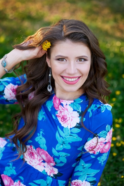 Retrato de uma mulher feliz com cachos e uma flor no cabelo