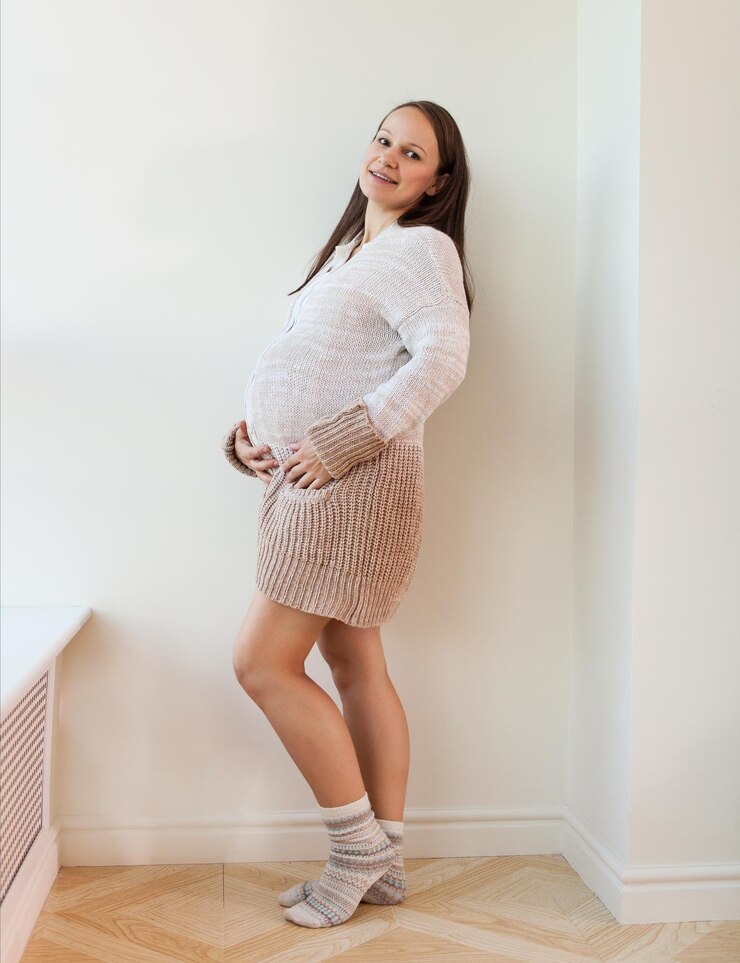 Foto retrato de uma mulher feliz de pé contra a parede em casa