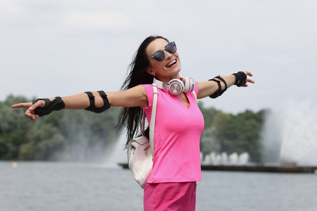 Foto retrato de uma mulher feliz e sorridente em óculos de sol no fundo do conceito de caminhada de verão da fonte