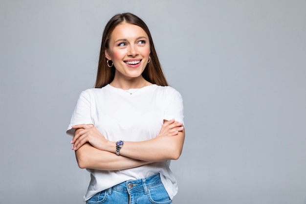 Retrato de uma mulher feliz em pé com os braços cruzados isolados