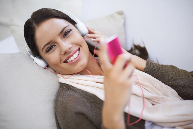 Foto retrato de uma mulher feliz jogador ou fones de ouvido para podcast de música ou rádio streaming em casa break relaxar ou pessoa feminina ouvindo com leitor de áudio no sofá em lounge para música de som ou faixa