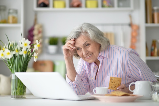 Retrato de uma mulher idosa alegre com laptop