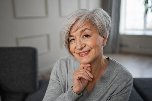 Retrato de uma mulher idosa de meia-idade europeia confiante e elegante, madura e sorridente em casa.