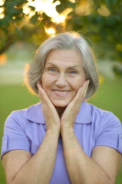 Retrato de uma mulher idosa feliz no parque outono