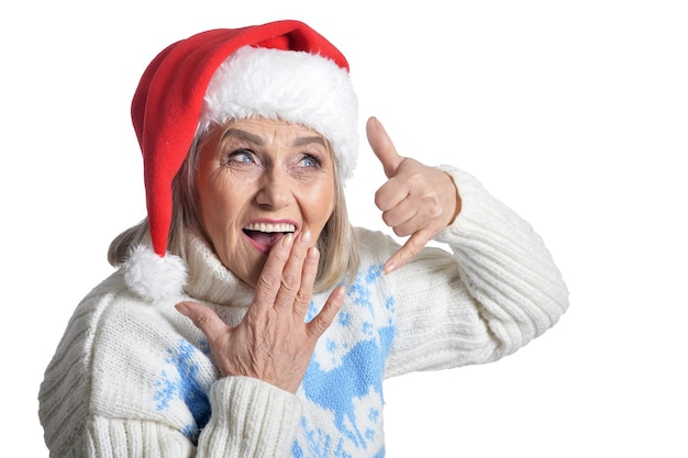 Retrato de uma mulher idosa feliz sorridente com chapéu de Papai Noel mostrando sinal de chamada