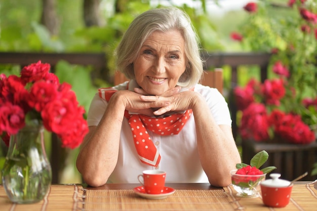 Retrato de uma mulher idosa feliz tomando café