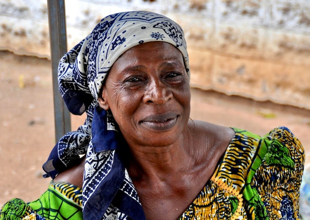Retrato de uma mulher idosa sorrindo e usando um lenço na cabeça
