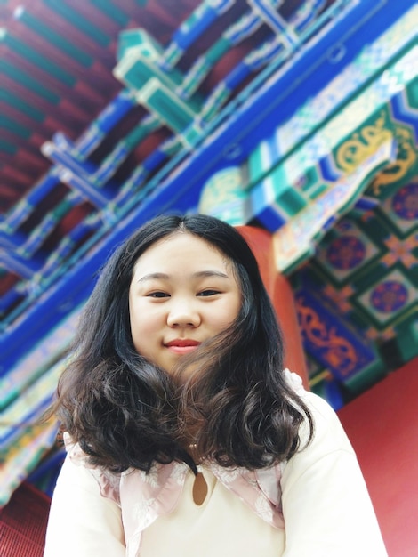 Foto retrato de uma mulher jovem contra uma estrutura construída