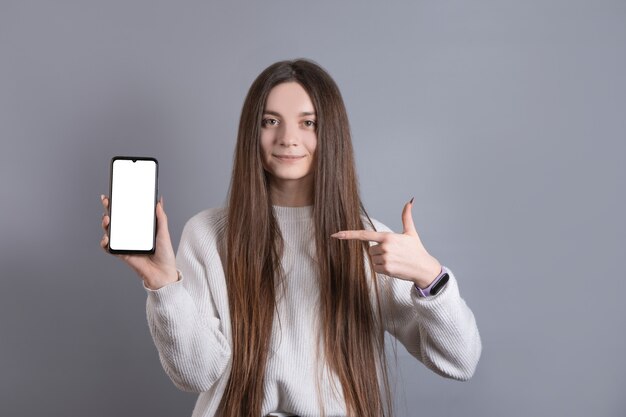 Retrato de uma mulher jovem e atraente com cabelo comprido escuro, facilmente sorrindo e apontando