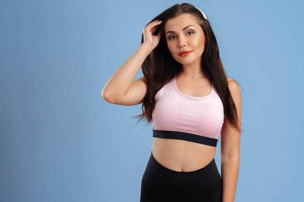 Retrato de uma mulher jovem fitness sportswear posando no estúdio
