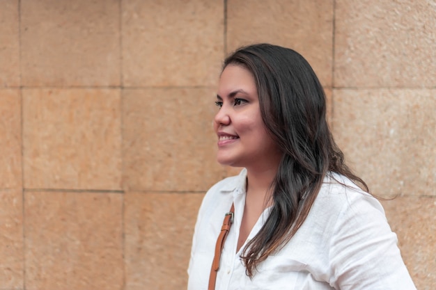 Retrato de uma mulher latina sorridente andando na rua