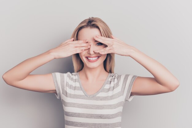 Foto retrato de uma mulher loira atraente cobrindo os olhos